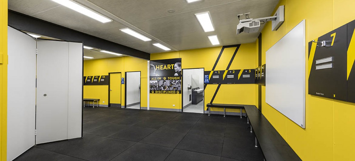 Interior Sports Change Room with Yellow Walls, Bifold Door and Bench Seating