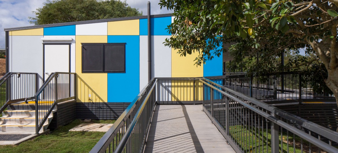 Multi-Coloured Modular Building with Cement Ramp and Grey Railings