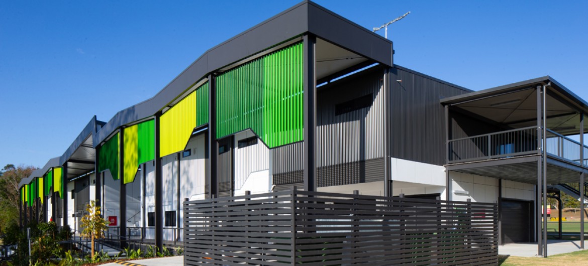Modular Building with Green Facade, Grey Awnings and Fencing