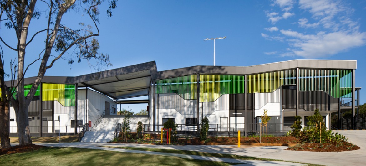 Modular Building on Lawn, with Grey Awnings and Green Facade